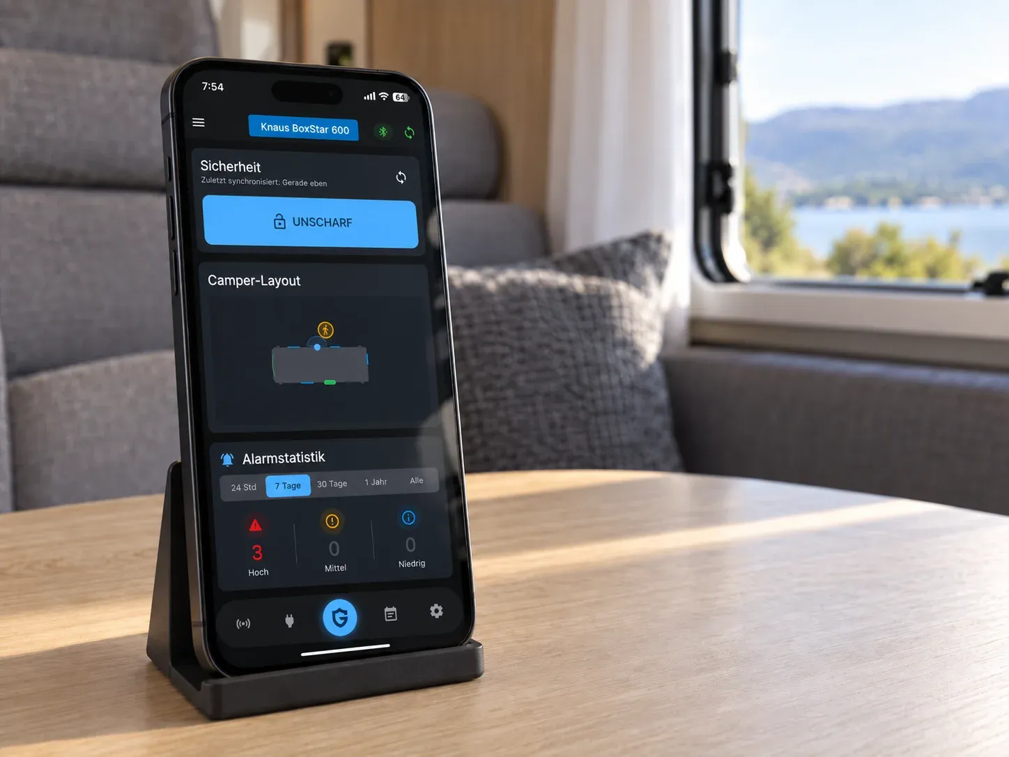 Smartphone mit CamperGuard Systemstatus auf dem Tisch im Wohnmobil