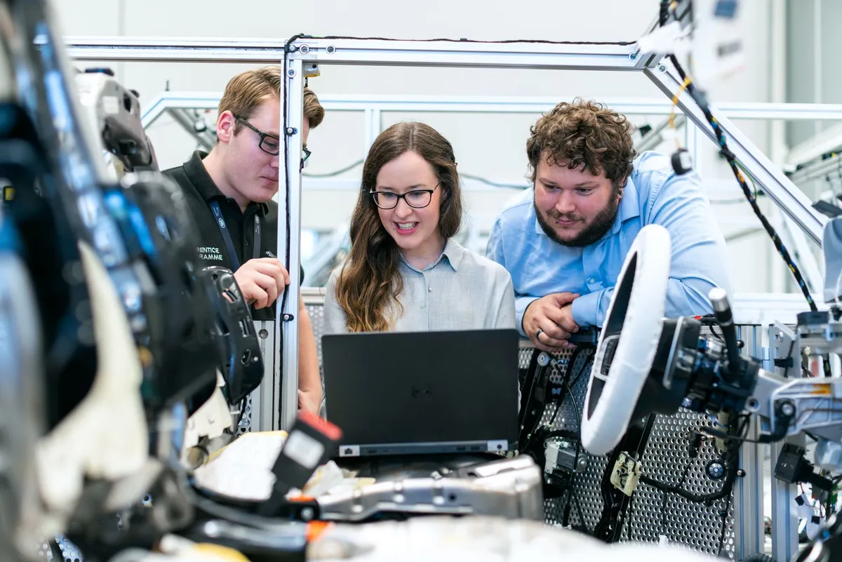 Automotive-Team bespricht technische Arbeit an einem Fahrzeugaufbau